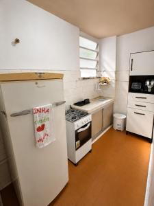 a kitchen with a white refrigerator and a stove at Apartamento em Botafogo 5 min de Copacabana in Rio de Janeiro