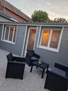 a group of chairs and tables in front of a house at Maisonnette à 350m de la plage in Berck-sur-Mer
