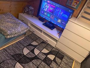 a room with a tv and a table with a gaming console at Domek Nad Morzem in Kołobrzeg