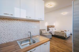a kitchen with a sink and a bed in a room at Dëshira Apartments in Ulcinj