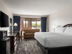 a hotel room with a bed and a couch at Avalon Hotel & Conference Center in Chippewa Falls