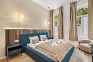 a bedroom with a bed and a chair and windows at dreamfactory Residence - Royal Westside in Vienna