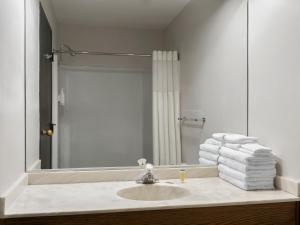 a bathroom with a sink and a mirror and towels at Avalon Hotel & Conference Center in Chippewa Falls +14 photos