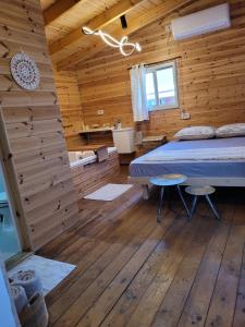 a bedroom with a bed in a wooden cabin at Serenity Cabin in Dalia in Dāliyat el Karmil