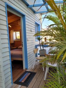 a porch of a house with a bed and a door at Serenity Cabin in Dalia in Dāliyat el Karmil