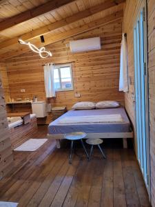 a bedroom with a bed in a wooden cabin at Serenity Cabin in Dalia in Dāliyat el Karmil