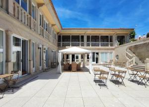 a patio with tables and chairs and an umbrella at LÚA Cies Room in Oya
