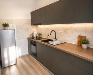 a kitchen with a sink and a refrigerator at Rion Apartments in Saturn +3 photos