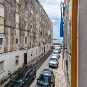 a street with cars parked on the sides of buildings at A Casa do Jamor in Cruz Quebrada