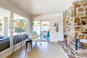a living room with a stone fireplace and a chair at Desert Retreat in Indian Wells +27 photos