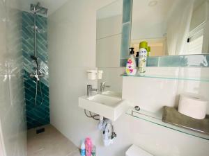 a bathroom with a sink and a mirror and a shower at Ático Cádiz Suite in Cádiz +32 photos