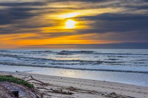 a sunset on a beach with the ocean at Monterey Dune Dream in Moss Landing