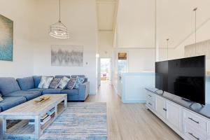 a living room with a blue couch and a tv at Monterey Dune Dream in Moss Landing