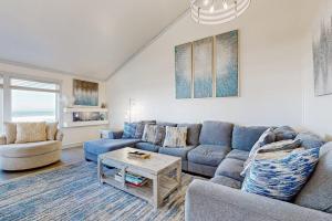 a living room with a blue couch and a table at Monterey Dune Dream in Moss Landing