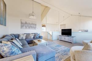 a living room with a blue couch and a tv at Monterey Dune Dream in Moss Landing +28 photos