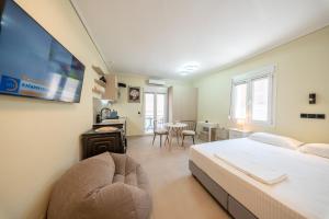 a bedroom with a bed and a tv and a table at Modern Studios for Two in Mytilene