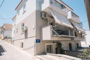 a white building with balconies on a street at Modern Studios for Two in Mytilene