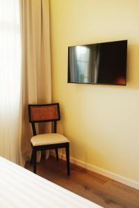 a chair in a room with a tv on the wall at Hotel "Villa Niche" By Bratheim in Tirana