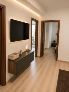a living room with a flat screen tv on a wall at Rion Apartments in Saturn