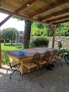 a wooden table and chairs under a wooden pergola at La casa di Simona in Pistoia