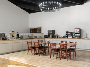 a kitchen with a table and chairs in a room at Avalon Hotel & Conference Center in Chippewa Falls