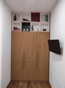 a room with wooden cabinets and a flat screen tv at La casa di Simona in Pistoia +11 photos