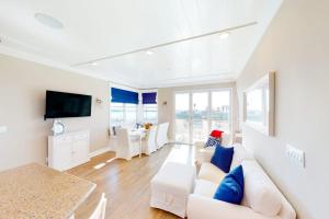 a living room with a white couch and a table at Gull Cottage in Seal Beach