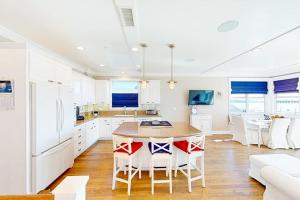 a kitchen with white cabinets and a table and chairs at Gull Cottage in Seal Beach