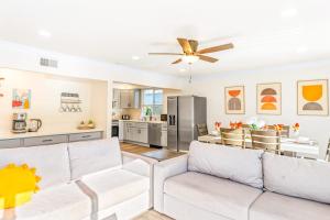a living room with two white couches and a kitchen at Seashore Dreams B - Upper Unit in Newport Beach