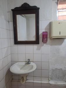 a bathroom with a sink and a mirror on the wall at Suíte Centro Histórico in São Luís