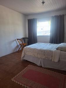a bedroom with a bed and a window and a rug at Suíte Centro Histórico in São Luís