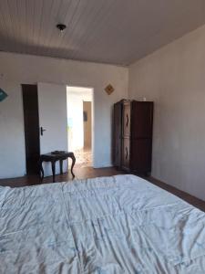 an empty bedroom with a large bed and a cabinet at Suíte Centro Histórico in São Luís