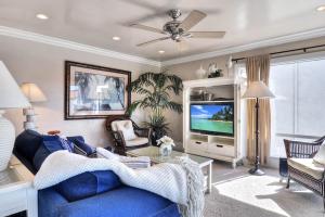 a living room with a blue couch and a tv at San Clemente - Monterey Fourplex in San Clemente