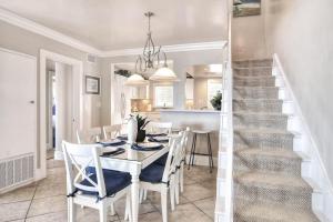 a dining room with a table and chairs and a staircase at San Clemente - Monterey Fourplex in San Clemente