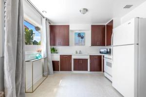 a kitchen with brown cabinets and a white refrigerator at San Clemente Sunset in San Clemente +18 photos