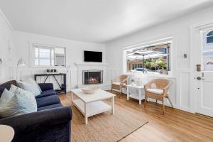 a living room with a blue couch and a fireplace at Newport Coastal Charm in Newport Beach