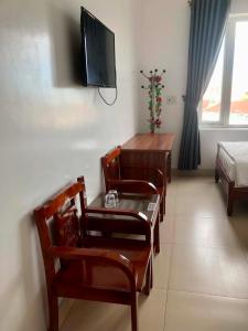 a room with chairs and a table and a television at Thanh Dat 2 Hotel in Vinh +17 photos