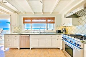 a kitchen with white cabinets and a view of the ocean at Tommy Bahama Beach Rd II in Dana Point