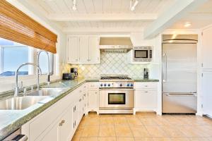 a white kitchen with a sink and a refrigerator at Tommy Bahama Beach Rd II in Dana Point