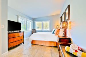 a bedroom with a bed and a flat screen tv at Tommy Bahama Beach Rd II in Dana Point