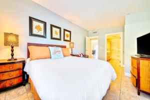 a bedroom with a white bed and a flat screen tv at Tommy Bahama Beach Rd II in Dana Point
