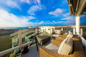 a balcony with wicker furniture and a view of the ocean at San Clemente Ocean Luxury Bluff Top in San Clemente