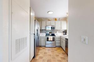 a kitchen with white appliances and a tile floor at Monarch Vista in Dana Point