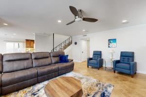 a living room with a couch and two blue chairs at Palm Tree Getaway in Newport Beach