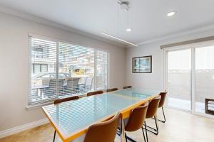 a dining room with a glass table and chairs at Palm Tree Getaway in Newport Beach