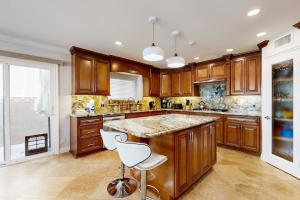 a kitchen with wooden cabinets and a large island at Palm Tree Getaway in Newport Beach