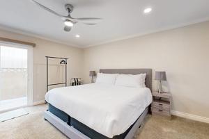 a bedroom with a large white bed and a window at Palm Tree Getaway in Newport Beach +21 photos