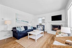 a living room with a blue couch and a fireplace at Newport Coastal Compound in Newport Beach