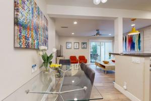 a living room with a glass table and red chairs at On the Doorstep in Anaheim