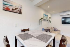 a white dining room table with chairs and a couch at Fair Weather in Newport Beach